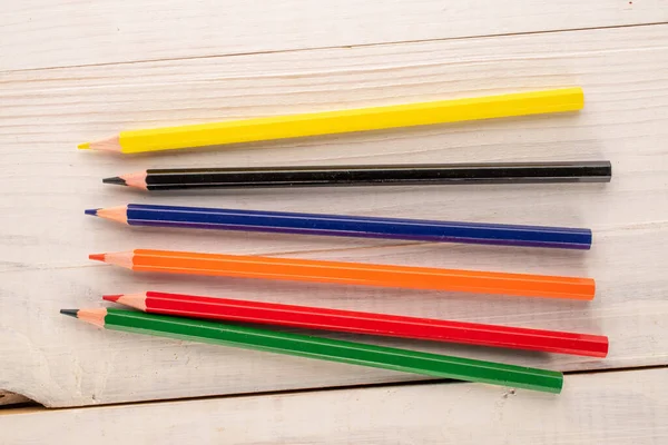 Ahşap bir masada birkaç renkli kalem, yakın plan, üst manzara..