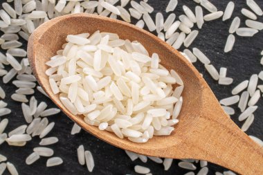 Beyaz pişmemiş pirinç, tahta kaşıkla, yakın plan, tahta tahtada, üst görünümde..