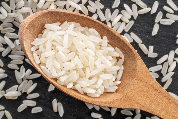 Beyaz pişmemiş pirinç, tahta kaşıkla, yakın plan, tahta tahtada, üst görünümde..