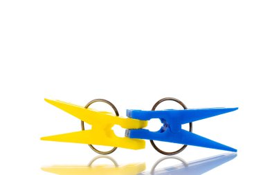 İki plastik mandal, makro, beyaz arka planda izole edilmiş..