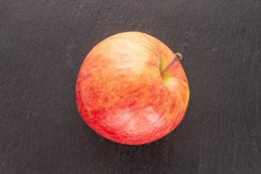 Tahta taşın üzerinde kırmızı organik bir elma, yakın plan, üst manzara..