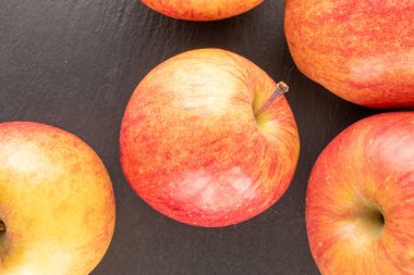 Tahta bir taşın üzerinde birkaç kırmızı organik elma, yakın plan, üst görünüm.