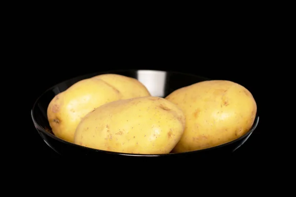 Three Raw Organic Potatoes Black Ceramic Plate Close Isolated Black — Zdjęcie stockowe