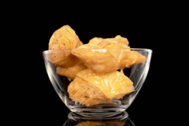 Cam bir kasede birkaç dilim bal baklavası, yakın plan, siyah arka planda izole edilmiş..