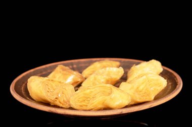 Kil tabakta birkaç dilim bal baklavası, makro, siyah arka planda izole edilmiş..