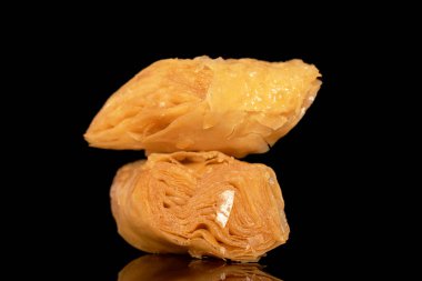 İki parça tatlı bal baklavası, yakın plan, siyah bir arkaplanda izole edilmiş..