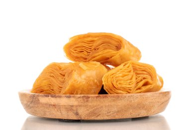 Tahta tepside birkaç dilim bal baklavası, yakın plan, beyaz arka planda izole edilmiş..
