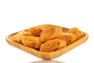 Tahta tepside birkaç dilim bal baklavası, yakın plan, beyaz arka planda izole edilmiş..