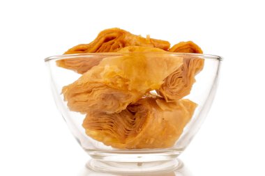 Cam bir kasede birkaç dilim bal baklavası, yakın plan, beyaz arka planda izole edilmiş..