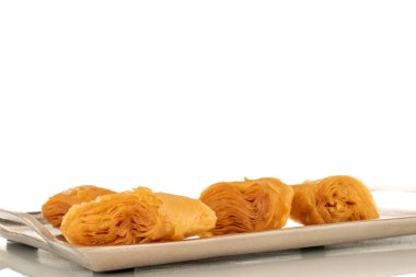 Metal tepside birkaç dilim bal baklavası, yakın plan, beyaz arka planda izole edilmiş..
