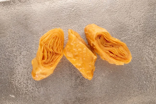 Metal bir tepside üç parça bal baklavası, yakın plan, üst manzara..