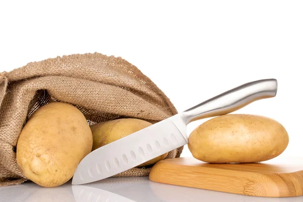几个新鲜的 没有剥皮的生的 有机的 多汁的土豆 有一把金属刀 一个黄麻袋和一个竹盘 白色背景 — 图库照片