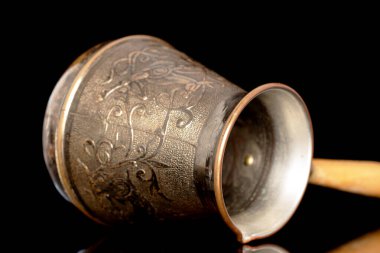 Tahta saplı bir Türk Cezve kahve demliği, siyah arka planda izole edilmiş yakın plan..