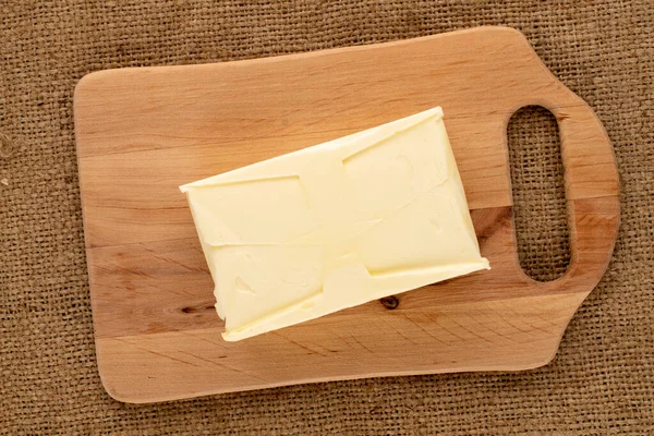 Pedaço Manteiga Deliciosa Uma Tábua Corte Madeira Pano Juta Close — Fotografia de Stock