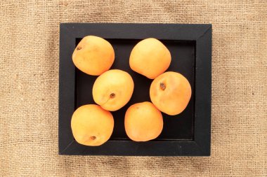 Çuval bezinde ahşap tepsiyle sulu, tatlı kayısılar..