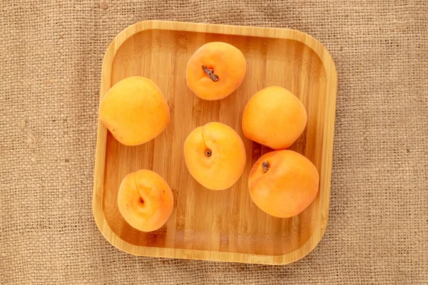 Çuval bezinde bambu tabağı olan sulu, tatlı kayısılar..