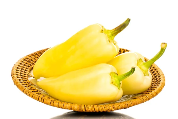 Seramik tabakta üç parlak sarı biber, yakın plan, beyaz arka planda izole edilmiş..