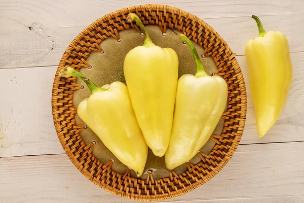 木製のテーブルの上にセラミック料理と4つの明るい黄色の甘いピーマン クローズアップ トップビュー — ストック写真