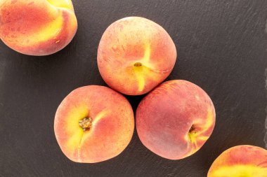 Birkaç sulu olgun şeftali, kayrak taşı üzerinde, yakın plan, üst manzara..