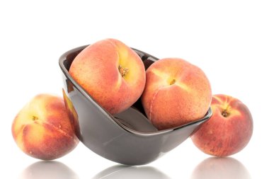 Siyah seramik plakalı birkaç tatlı organik şeftali, yakın plan, beyaz arka planda izole edilmiş..