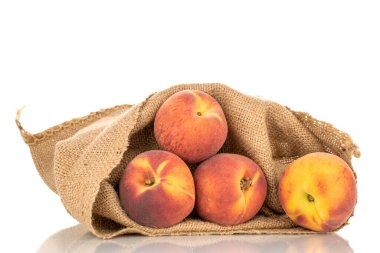 Birkaç tatlı organik şeftali, jüt çantalı, yakın plan, beyaz arka planda izole edilmiş..