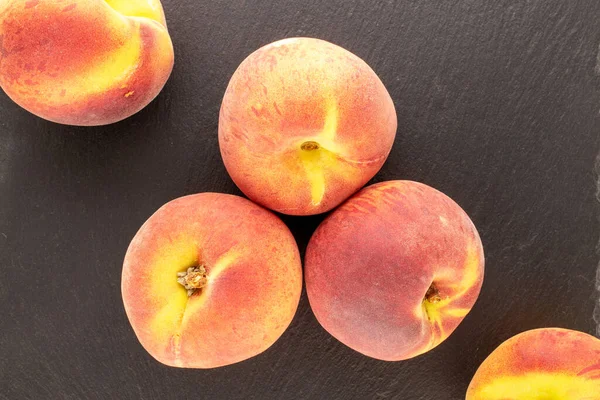 Birkaç sulu olgun şeftali, kayrak taşı üzerinde, yakın plan, üst manzara..