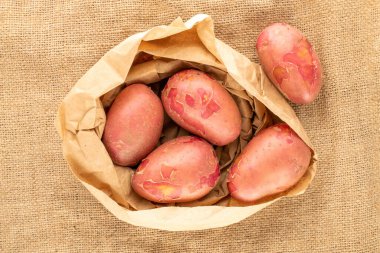 Çuval bezinde kese kağıdı olan birkaç organik pembe patates..