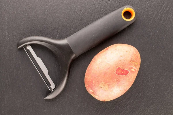 一个有机粉红土豆 石板上有一把刀 顶部视图 — 图库照片