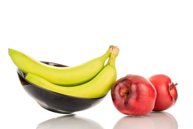 Üç tatlı sarı muz ve iki kırmızı elma, seramik tabakla, yakın plan, beyaz arka planda izole edilmiş..