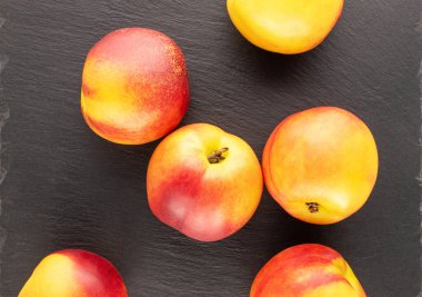 Birkaç olgun sulu nektarin kayrak taşı üzerinde, yakın plan, üst görünüm.