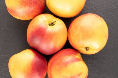 Birkaç olgun sulu nektarin kayrak taşı üzerinde, yakın plan, üst görünüm.