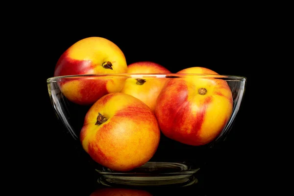 Cam bir kasede birkaç tatlı organik nektarin, siyah bir arka planda izole edilmiş yakın plan..