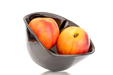 Siyah seramik plakalı iki sulu organik nektarin, yakın plan, beyaz arka planda izole edilmiş..