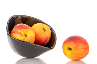 Siyah seramik plakalı üç sulu organik nektarin, yakın plan, beyaz arka planda izole edilmiş..