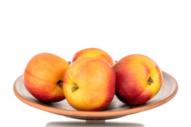 Birkaç sulu organik nektarin, seramik plaka, yakın plan, beyaz arka planda izole edilmiş..