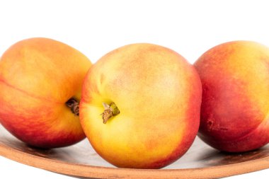 Seramik plakalı üç sulu organik nektarin, yakın plan, beyaz arka planda izole edilmiş..