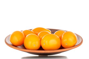 Seramik bir tabakta birkaç olgun sarı domates, yakın plan, beyaz arka planda izole edilmiş..