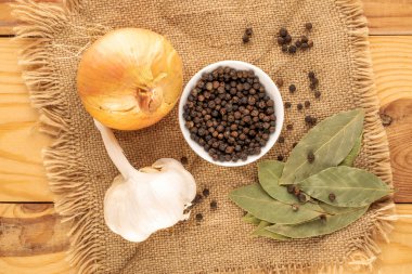 Kuru kokulu karabiber, defne yaprağı, soğan ve sarımsak çuval bezi, yakın çekim, üst manzara.