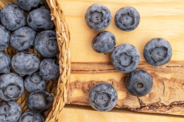 Hasır çatal bıçaklı organik yaban mersini, yakın plan, ahşap masa, üst görüş.