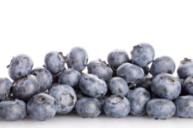 Beyaz arka planda birkaç tane organik olgun yaban mersini..