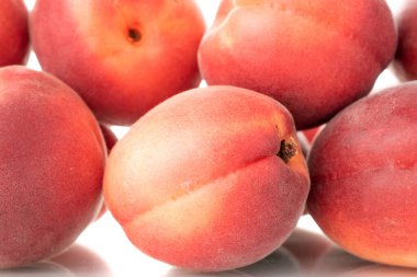 Birkaç tane olgun kırmızı kayısı, yakın plan, beyaz arka planda izole edilmiş..