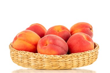 Bir saman tabaktaki birkaç olgun kırmızı kayısı, yakın plan, beyaz arka planda izole edilmiş..