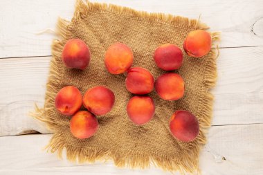 Bir kaç organik kayısı kırmızısı ve ahşap bir masanın üzerinde jüt peçete, yakın plan, üst manzara..