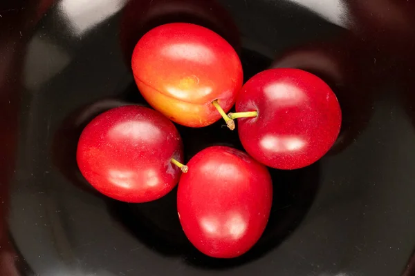Four Organic Juicy Cherry Plums Black Ceramic Dish Close Top — ストック写真