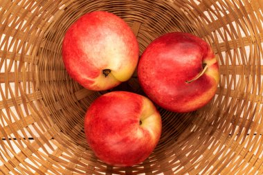 Hasır sepette üç tatlı nektarin, makro, üst manzara..