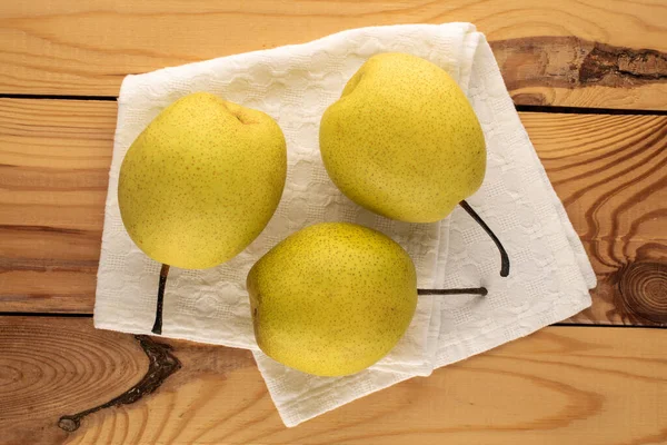 Three Sweet Bright Yellow Pears White Linen Napkin Wooden Table — ストック写真