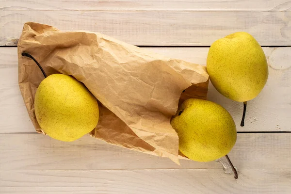Three Sweet Bright Yellow Pears Paper Craft Bag Wooden Table — Fotografia de Stock