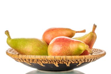 Four organic juicy pears in a ceramic plate, close-up, isolated on a white background.