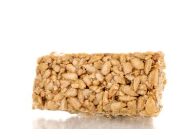 One sweet roasted candy from sunflower seeds and honey, close-up, isolated on a white background.