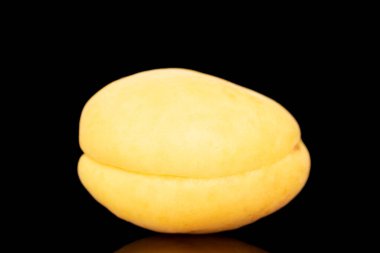 One bright yellow juicy apricot, macro, isolated on a black background.